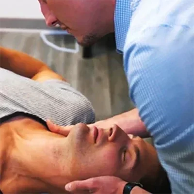 A chiropractor making a neck adjustment on a patient